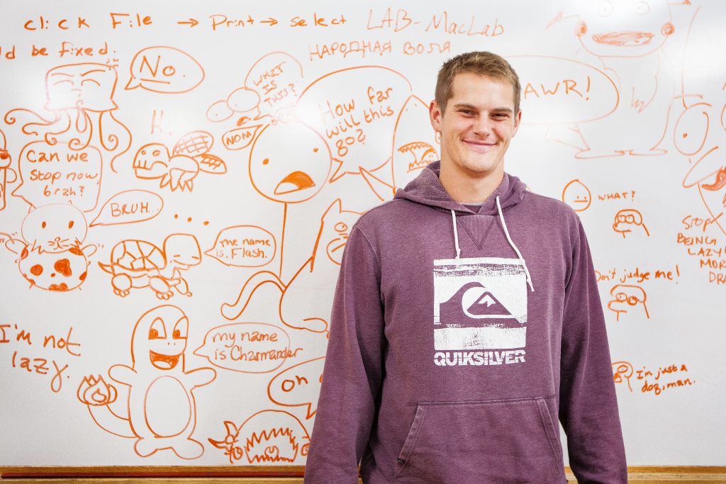 Illustration Major Student standing in front of doodles on whiteboard