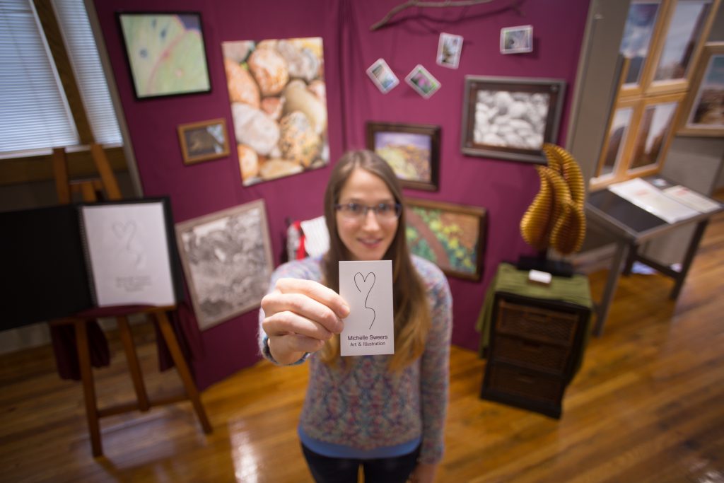 Student with her senior art display