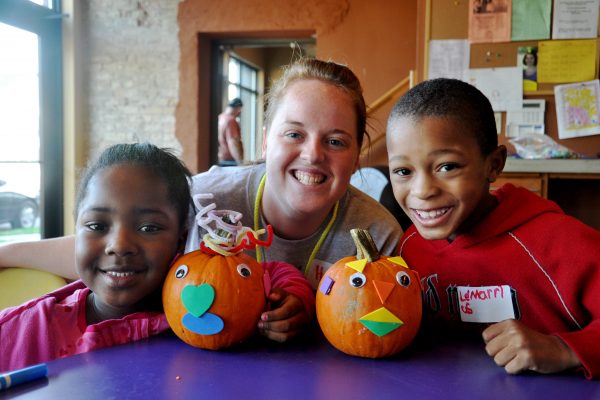Student with kids and decorated pumpkins