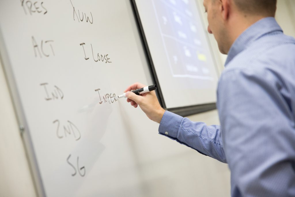 Professor writing on whiteboard