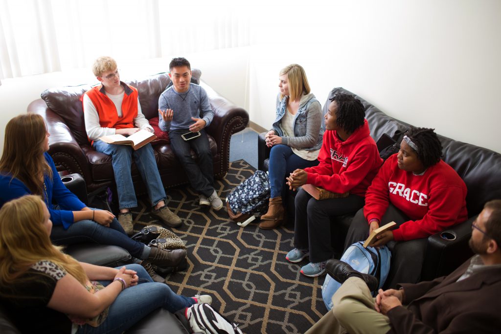 Students with professor sitting on couches having a discussion