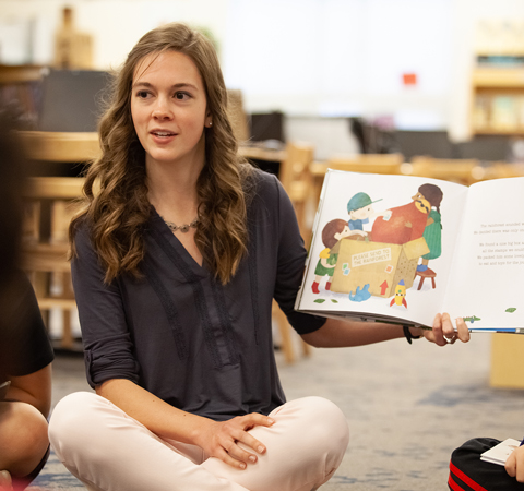 Student reading to children