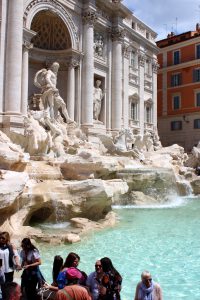 The Trevi fountain at noon, when many tourists crowd around the landmark.