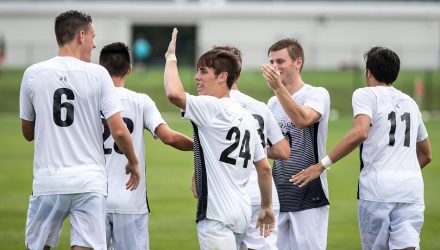 Mens soccer team high-fiving on the field