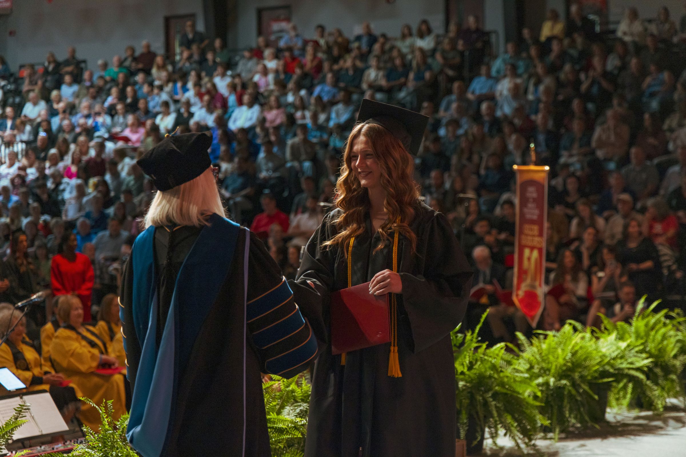 Grace College looks at the impact of AI on higher education. Is a college degree worth it? Learn about our Christian College in Indiana. Student receives diploma at commencement.